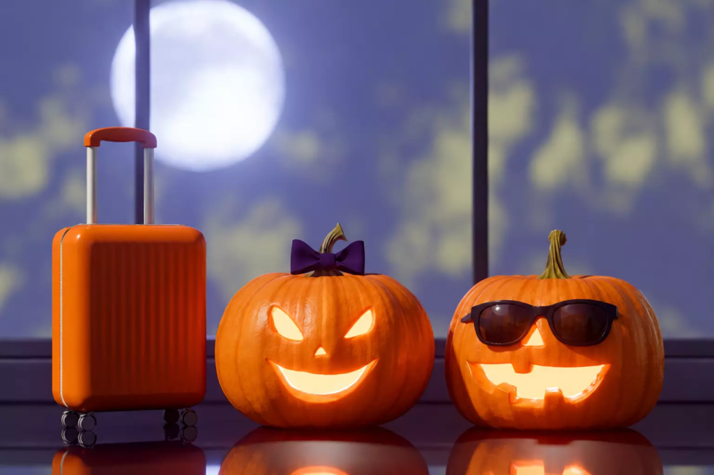 Valise orange et citrouilles sous la lune